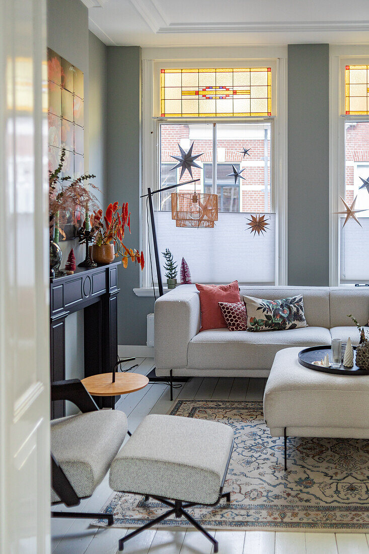 Living room with white corner sofa, vintage carpet and stained glass windows