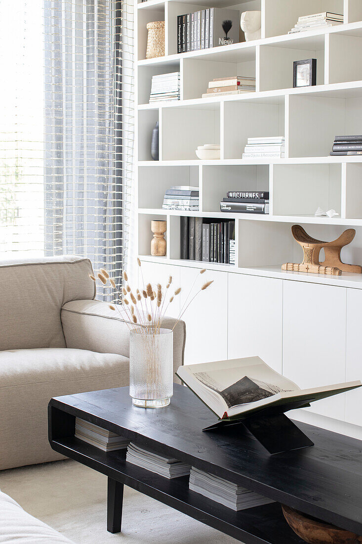 Modern living room with black coffee table and white built in wall shelf