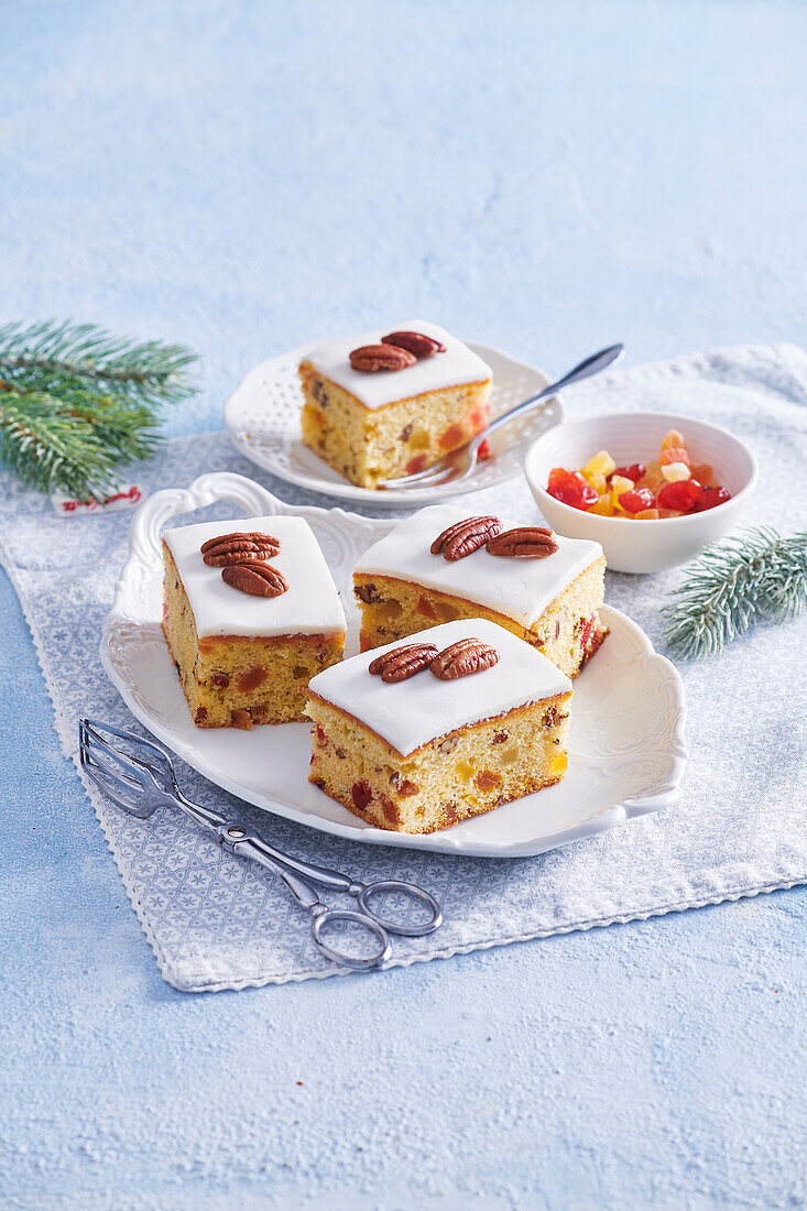 Sheet cake with candied fruit, pecan nuts and icing