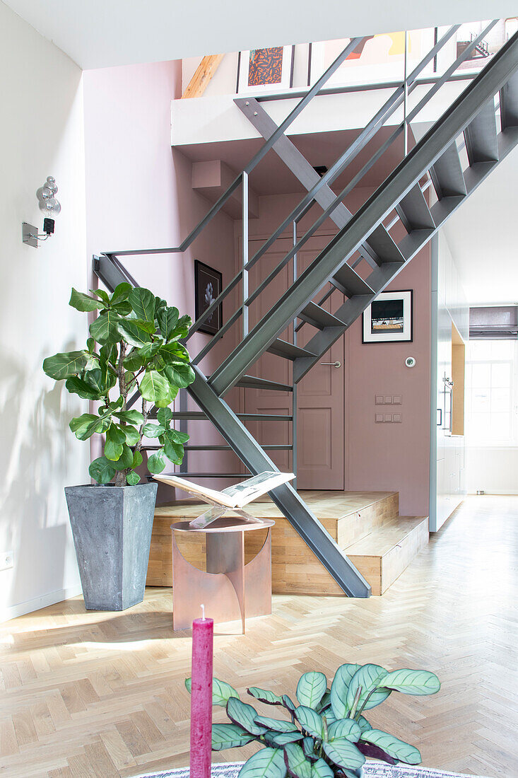 Metal staircase, plants and pictures in a modern living room