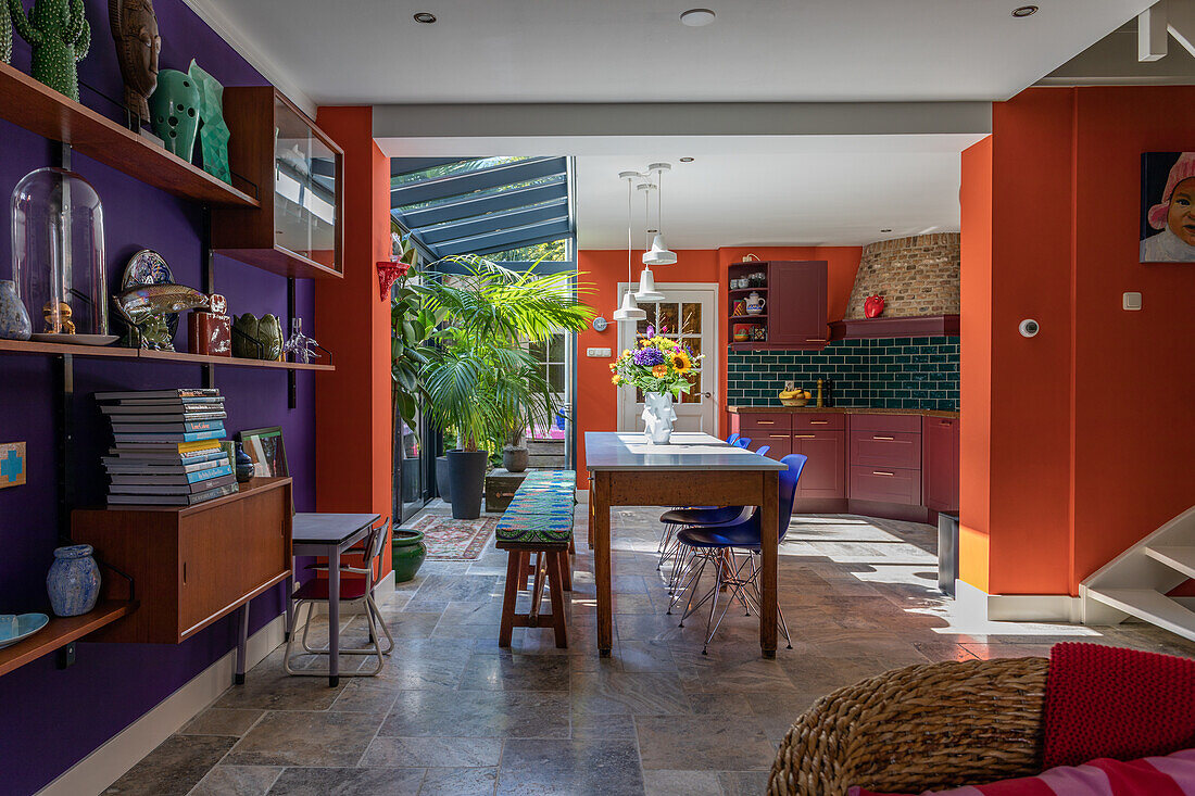 Open kitchen with dining area with colorful walls and glass roof