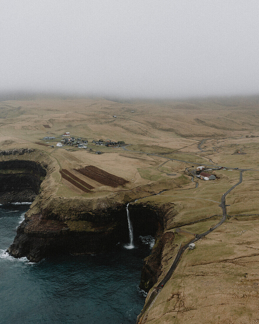 Luftaufnahme Wasserfall, der über eine Klippe ins Meer fließt, Gasadalur, Vagar, Färöer Inseln