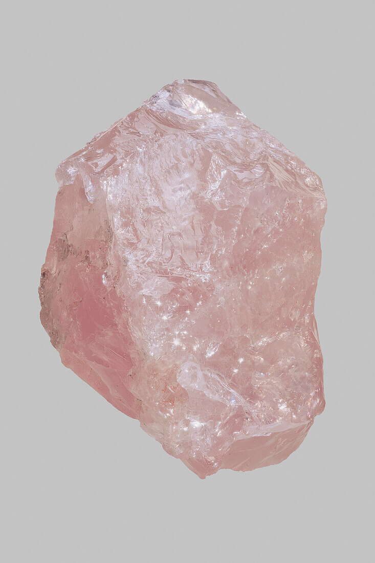 Close up pink Madagascan rose quartz stone on gray background\n