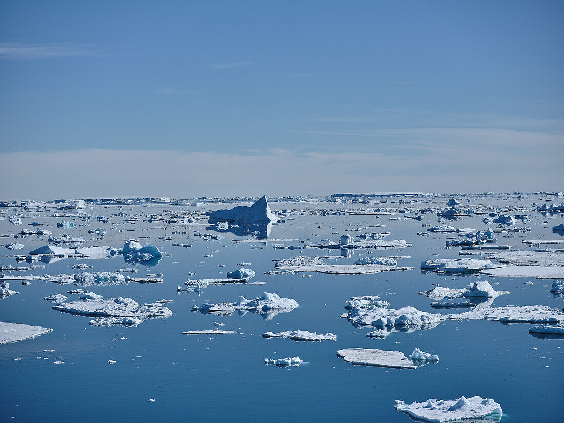 Schmelzende Gletschereisbrocken treiben auf der sonnigen Meeresoberfläche, Antarktische Halbinsel, Antarktis
