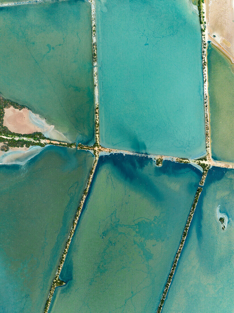 Aerial view of vibrant turquoise salt ponds, Majorca, Spain\n