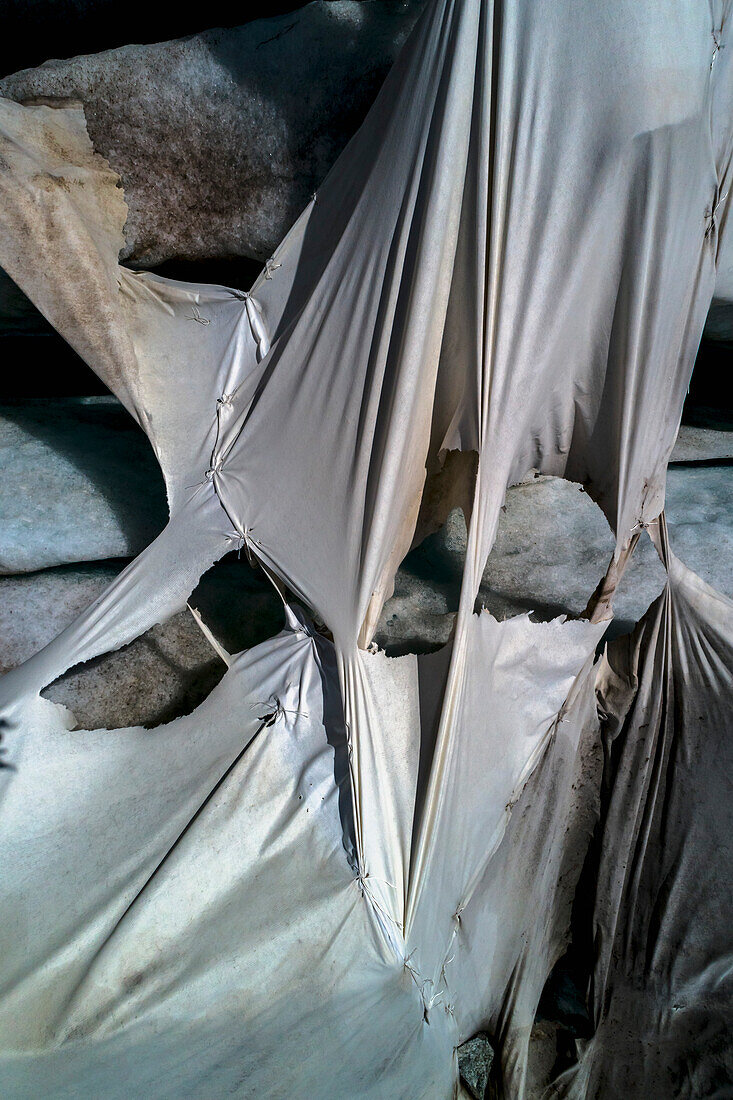 Aerial view ripped protective tarpaulin over Rhone Glacier, Switzerland\n