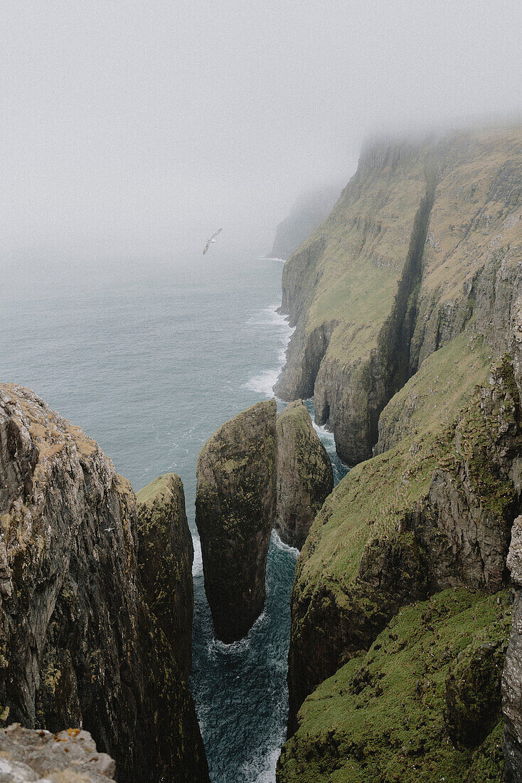 Majestic cliffs and sea stacks along ocean coastline, Dunnesdrangar, Vagar, Faroe Islands\n