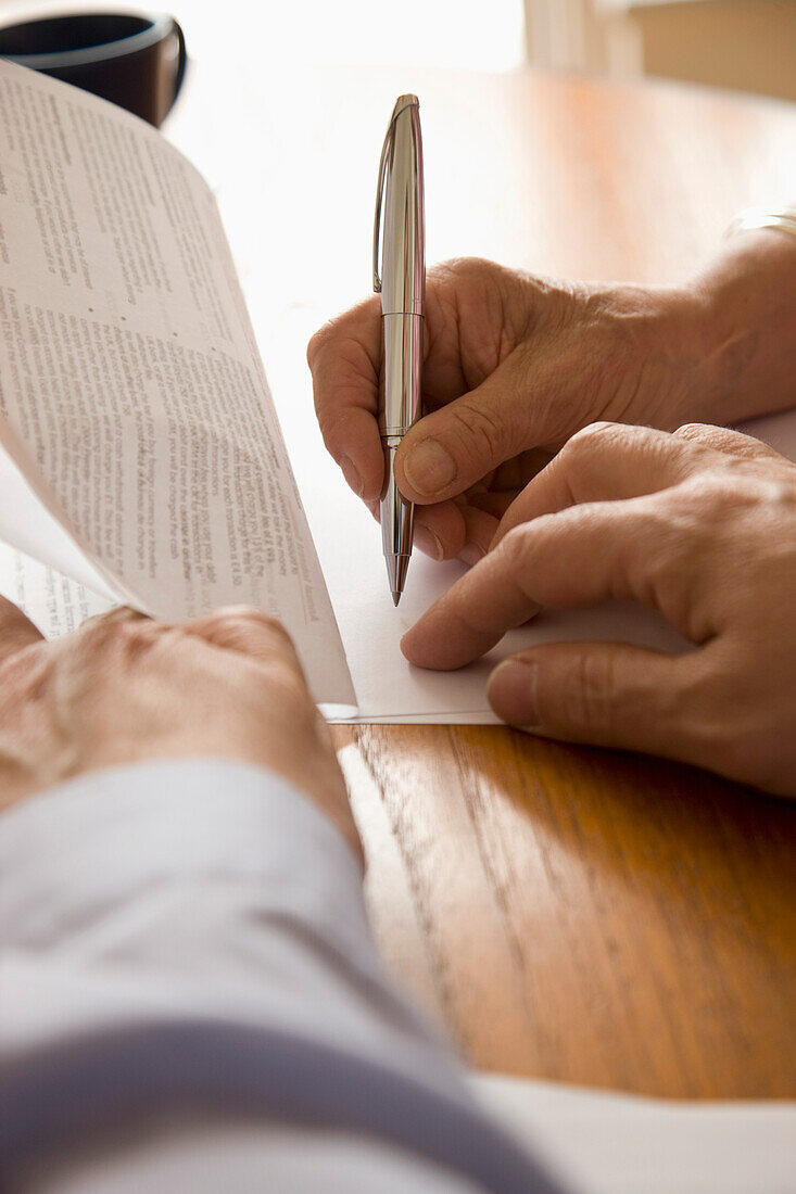 Nahaufnahme eines Mannes und einer Frau beim Unterschreiben von Dokumenten