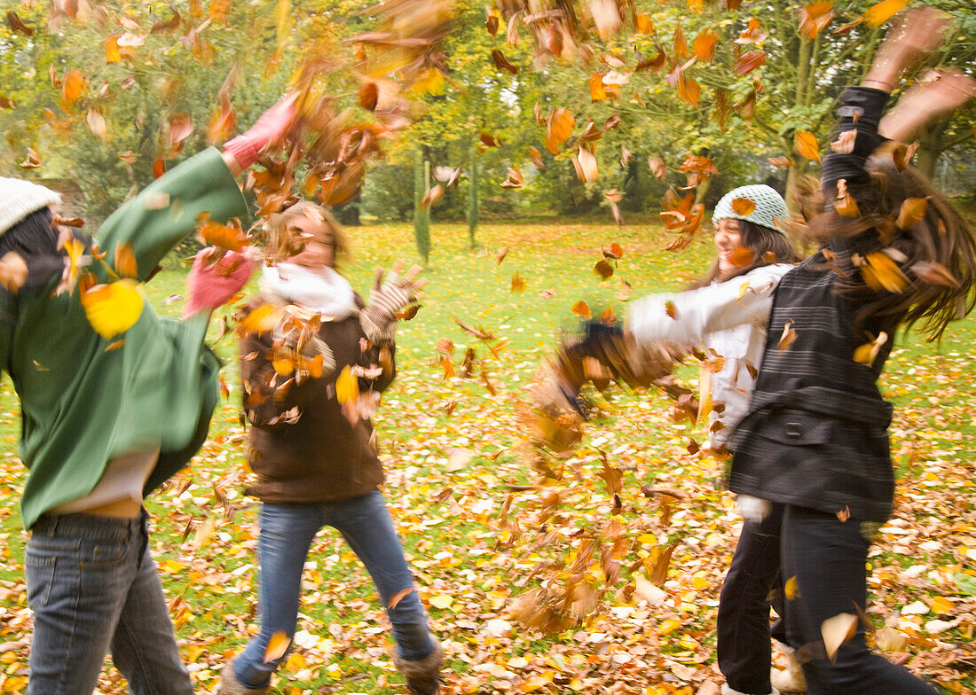 Junge Mädchen spielen mit Blättern im Park