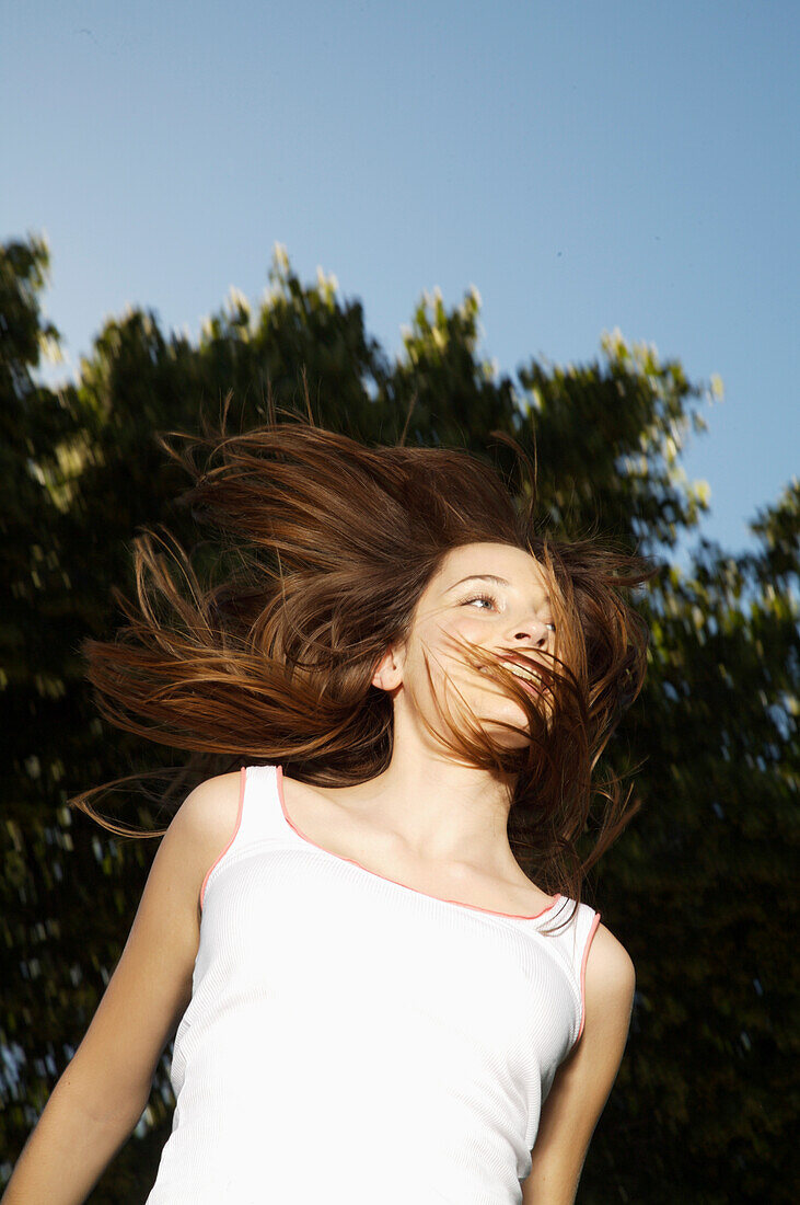 Portrait of a young woman jumping mid air\n