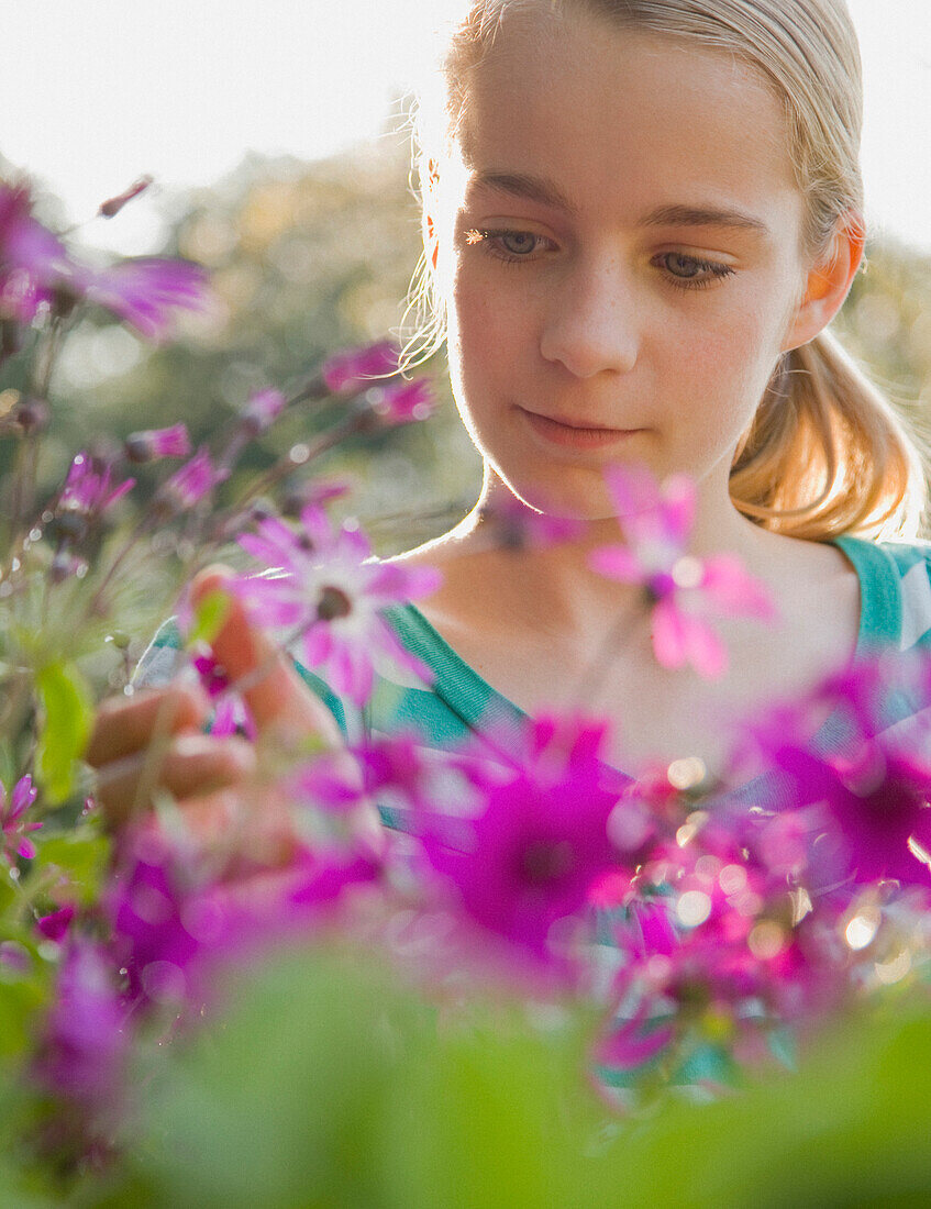 Nahaufnahme eines jungen Mädchens, das Blumen bewundert