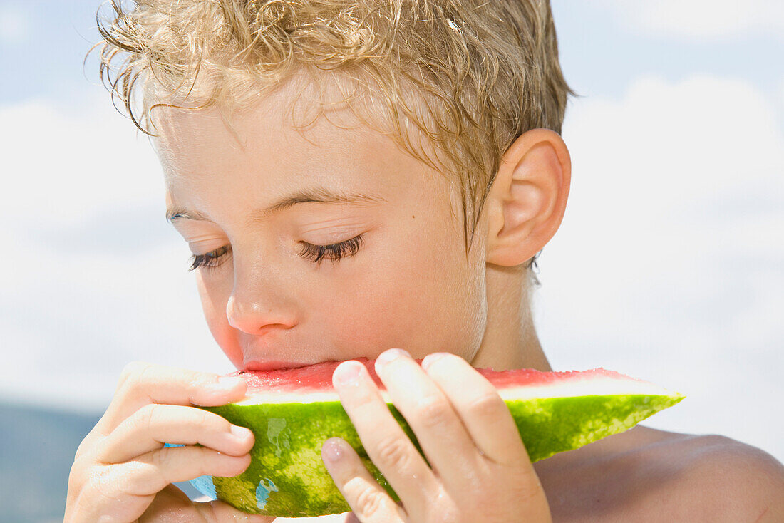 Junger Junge isst Wassermelone