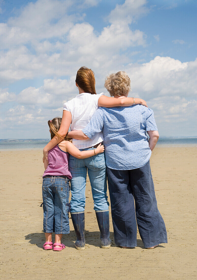 Rückenansicht von drei Frauen am Strand