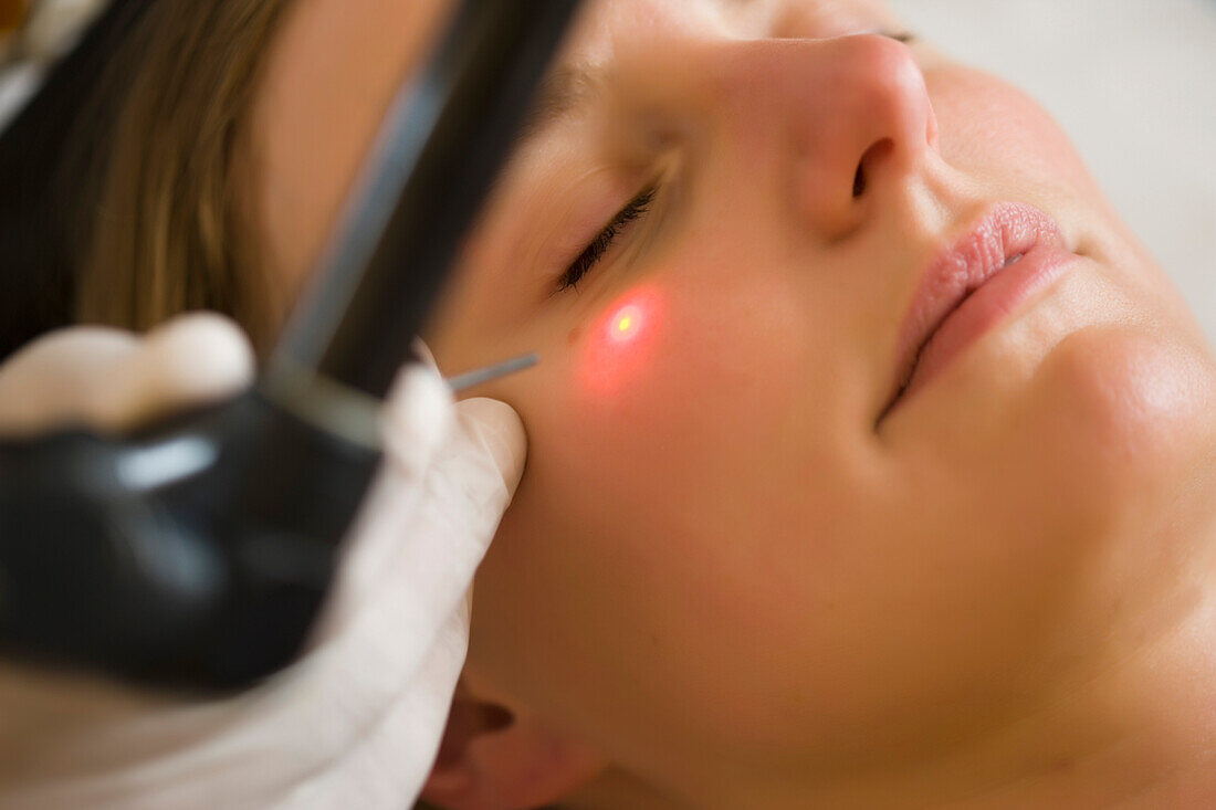 Close up of a woman receiving a laser treatment on her face\n