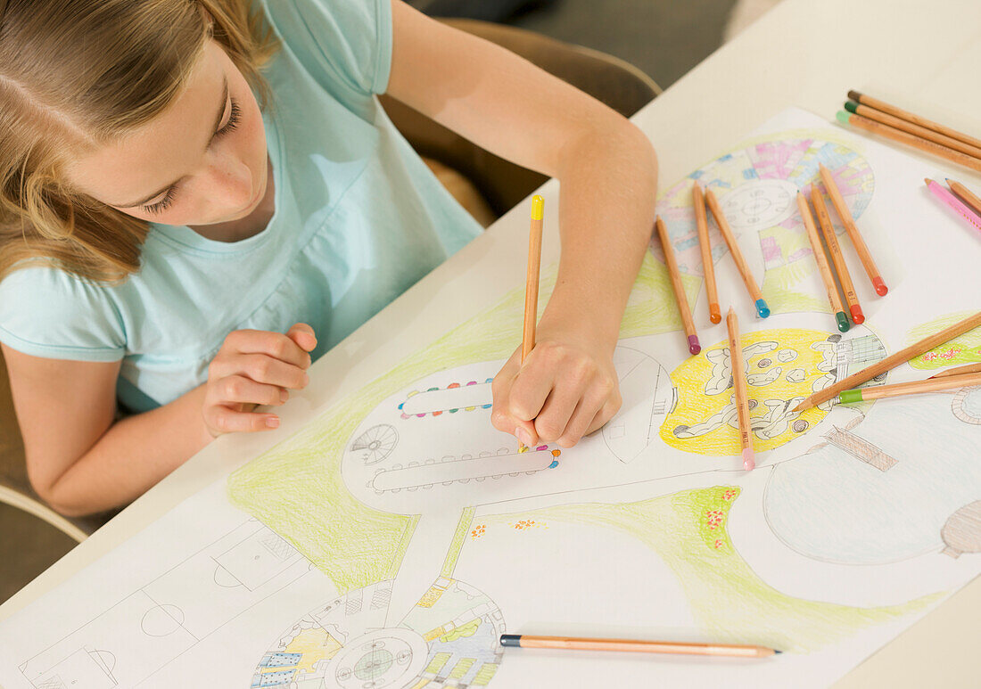 Young girl drawing with coloring pencil\n