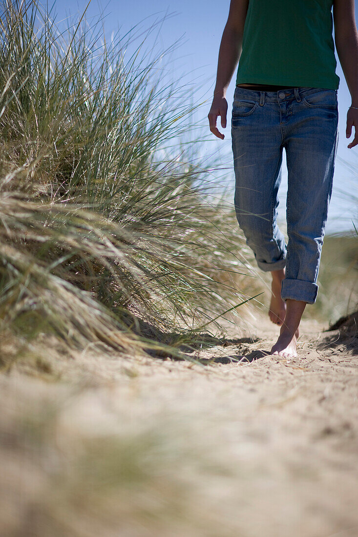 Barefoot young woman walking\n