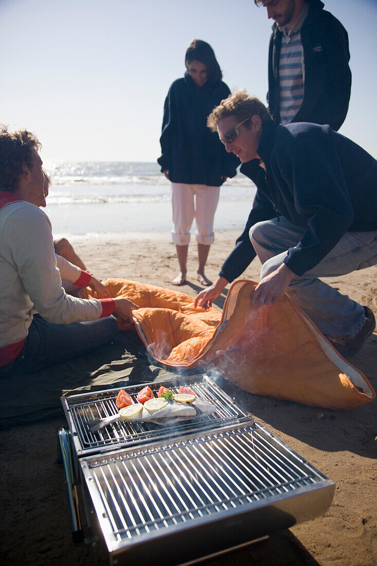 Freunde beim Grillen am Strand