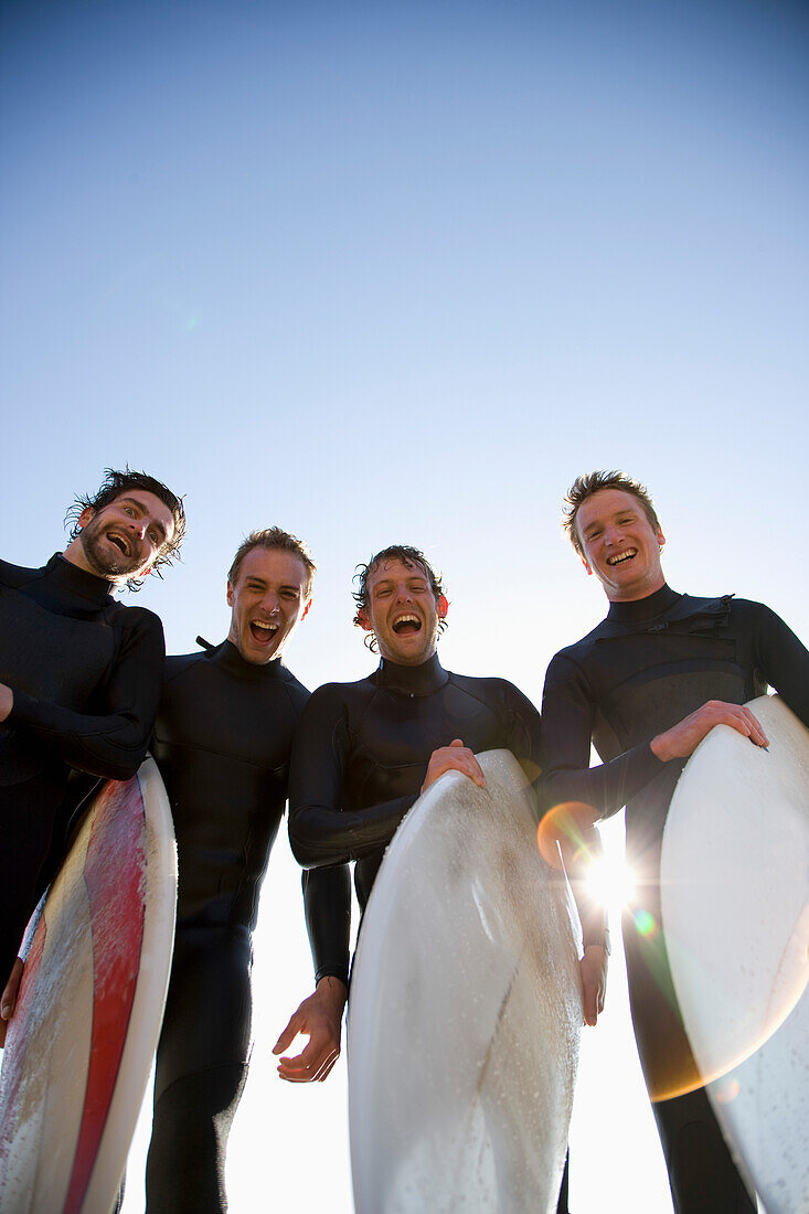 Surfers holding surfboards laughing and screaming\n