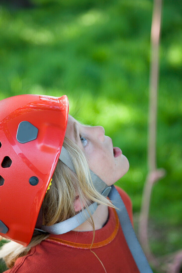 Young boy wearing a protective helmet looking up\n
