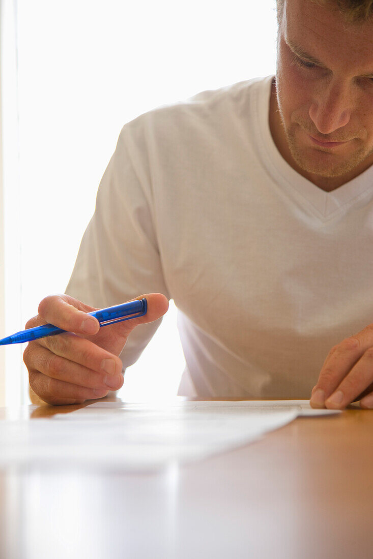 Close up of a man signing documents\n