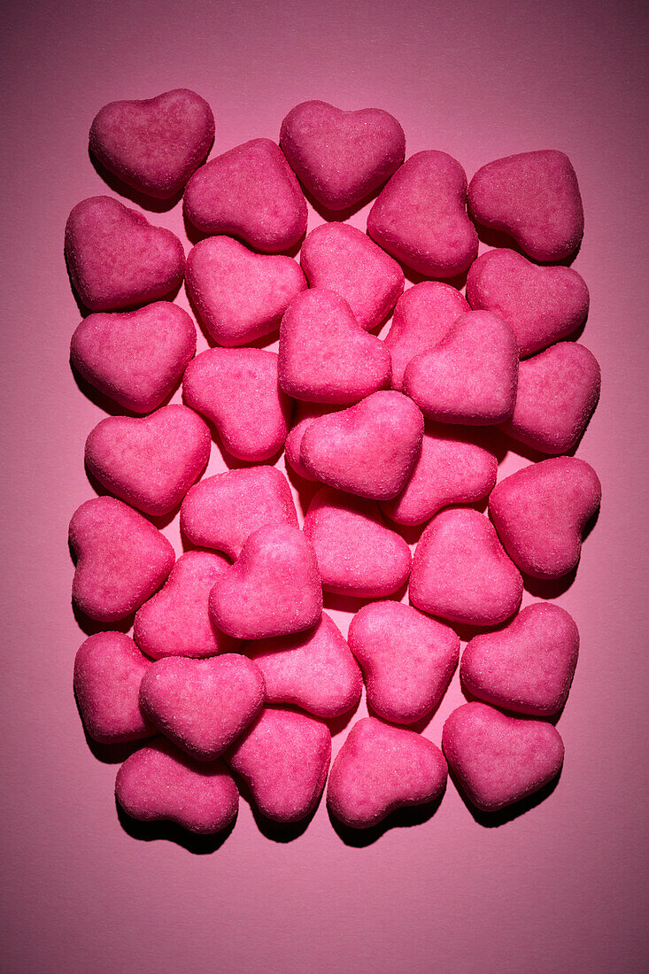 Still life pink heart candy on pink background\n