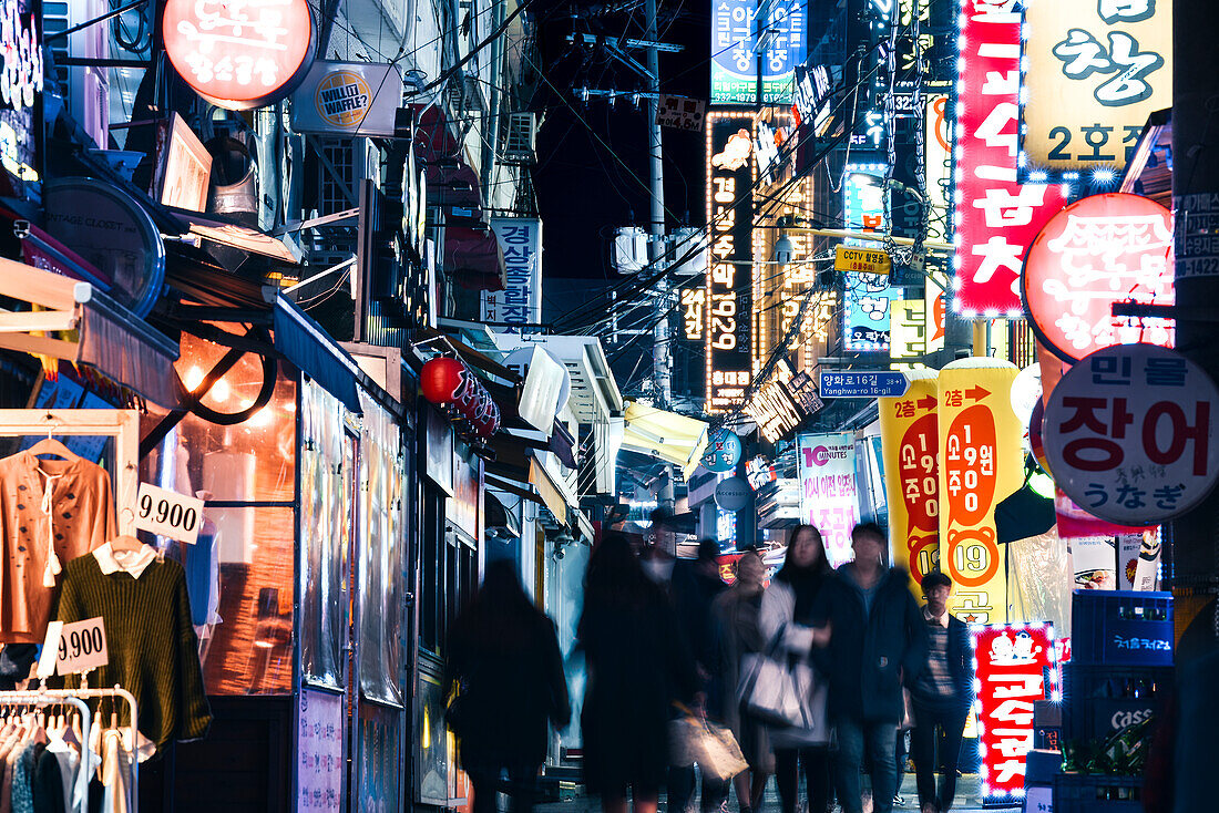 A bustling street scene at night in in Seoul's student district, Seoul, South Korea, Asia\n