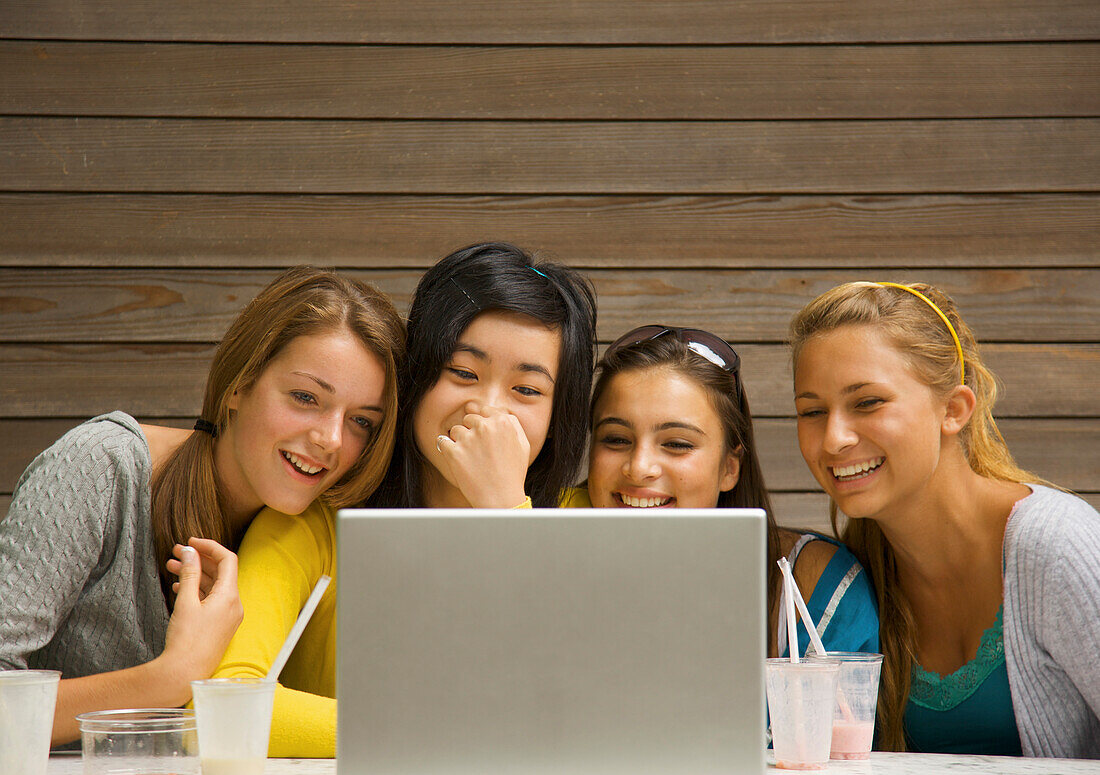 Mädchen im Teenageralter benutzen Laptop-Computer und lachen