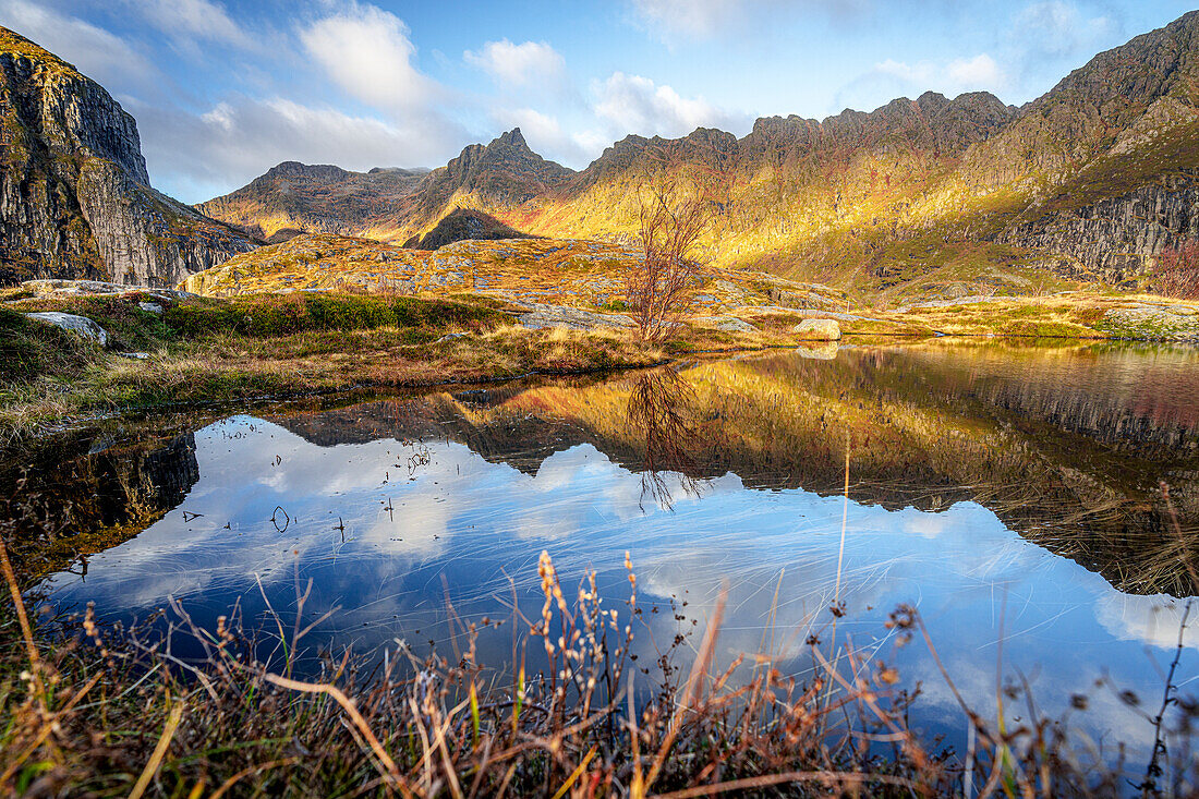 Autumn colors over mountains reflected in the sea, A i Lofoten, Moskenes, Lofoten Islands, Nordland, Norway, Scandinavia, Europe\n