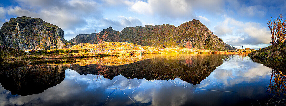 Panoramic of mountains reflected in the calm waters of a fjord at dawn, A i Lofoten, Moskenes, Lofoten Islands, Nordland, Norway, Scandinavia, Europe\n