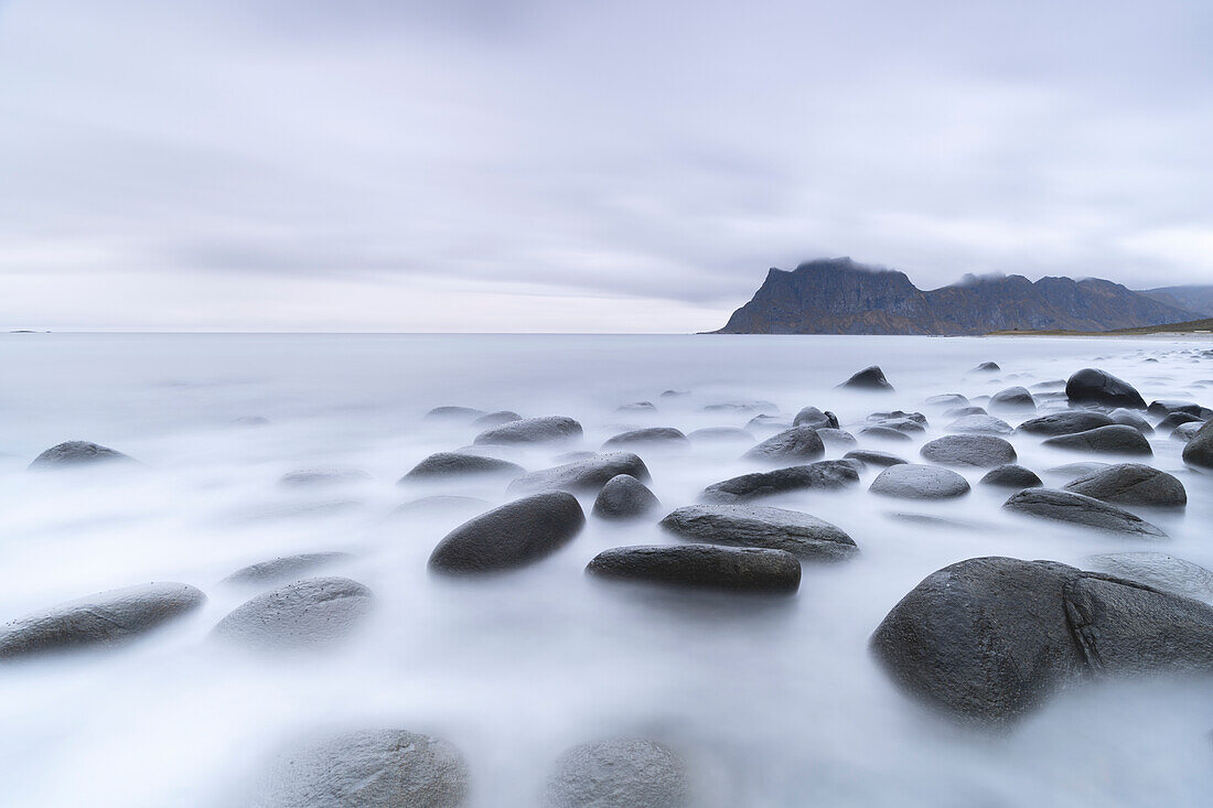 Clouds at dusk over rocks washed by the Arctic sea at Uttakleiv beach, Vestvagoy, Lofoten Islands, Nordland, Norway, Scandinavia, Europe\n