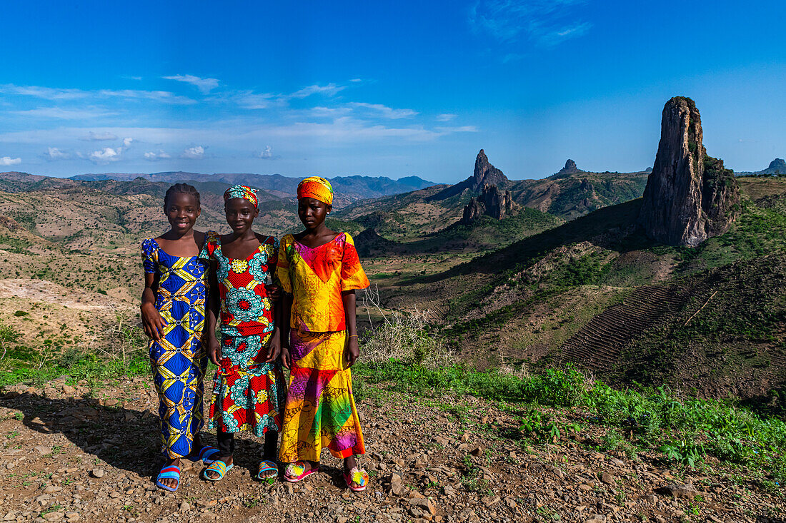 Three Kapsiki tribal girls in front of the lunar landscape, Rhumsiki, Mandara mountains, Far North province, Cameroon, Africa\n
