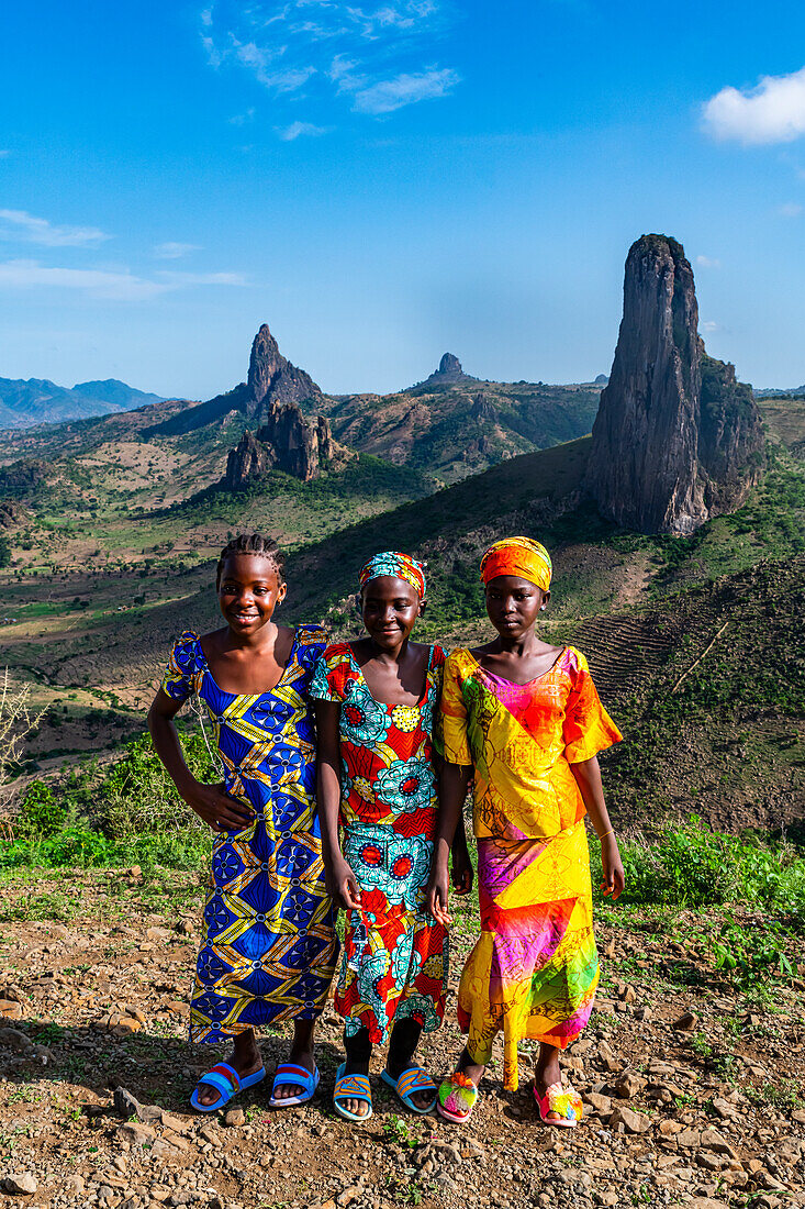 Three Kapsiki tribal girls in front of the lunar landscape of Rhumsiki , Rhumsiki, Mandara mountains, Far North province, Cameroon, Africa\n