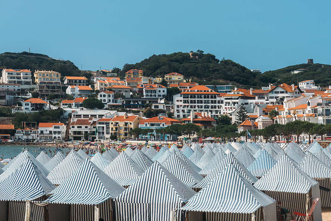Blick auf grüne Hütten am Strand von Sao Martinho do Porto, einem breiten, weißen Sandstrand, der von Dünen umgeben ist, in einer abgelegenen, bei Familien beliebten Bucht, Oeste, Portugal, Europa