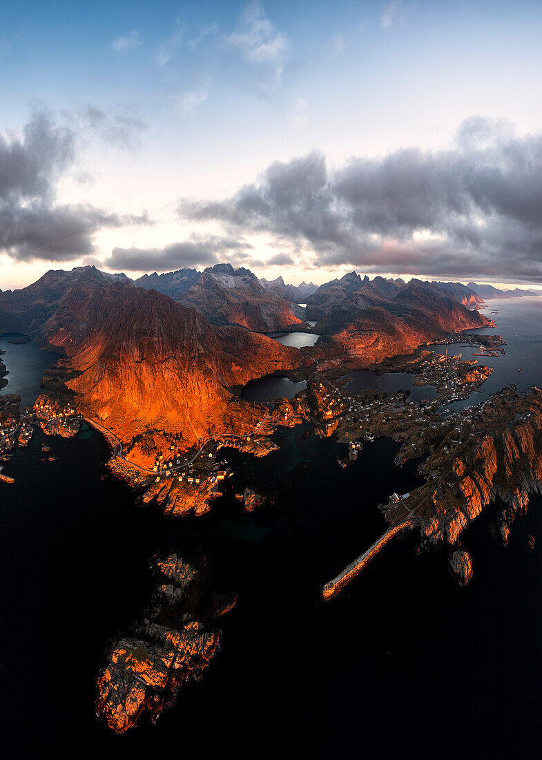 Panoramablick aus der Luft auf das Küstendorf Tind eingerahmt von Bergen bei Sonnenuntergang, Lofoten Inseln, Nordland, Norwegen, Skandinavien, Europa
