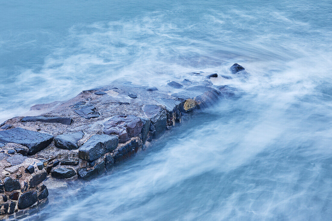 Bei steigender Flut stößt die Abendbrandung an die historische Hafenmauer bei Hartland Quay, an der Atlantikküste von Devon, England, Vereinigtes Königreich, Europa