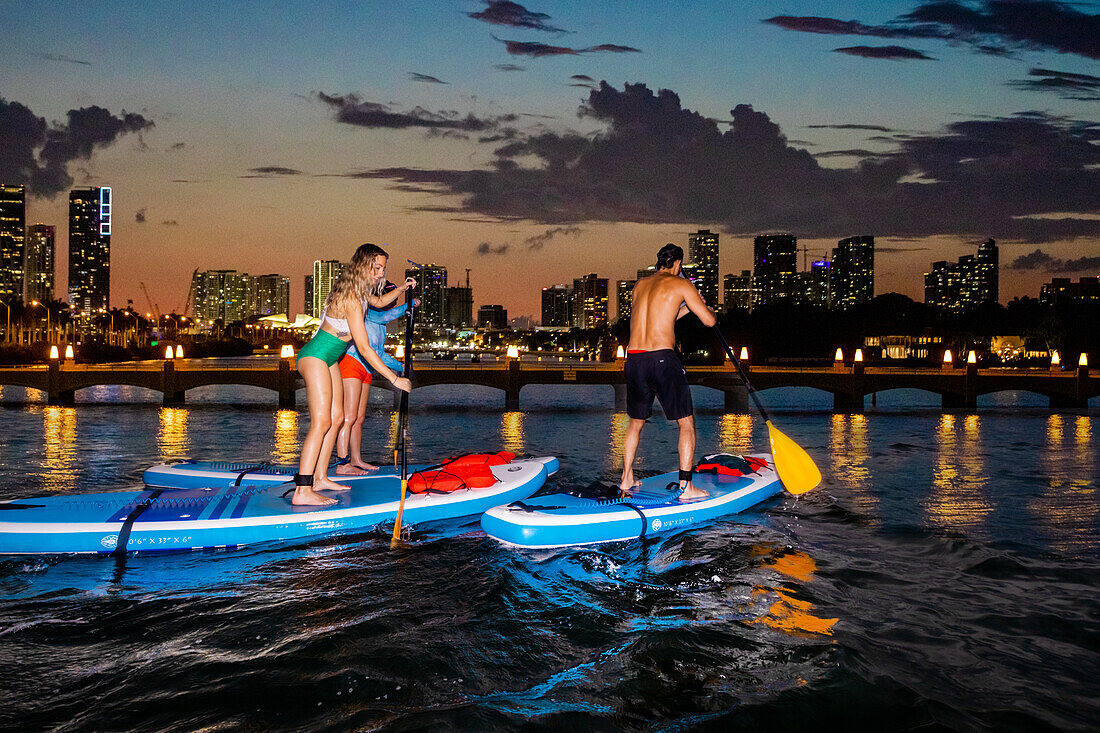 Paddle Boarding bei Nacht am Miami Beach, Miami, Florida, Vereinigte Staaten von Amerika, Nordamerika
