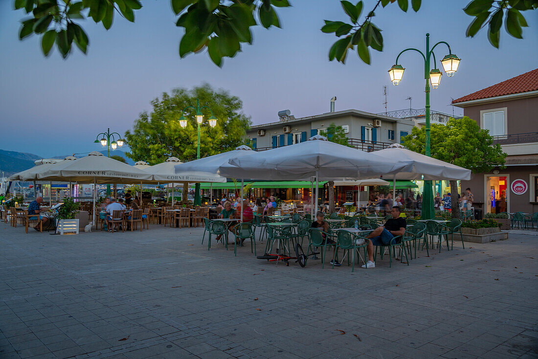 Blick auf Café und Bar am PlateA?a Central Square in der Abenddämmerung, Lixouri, Kefalonia, Ionische Inseln, Griechische Inseln, Griechenland, Europa