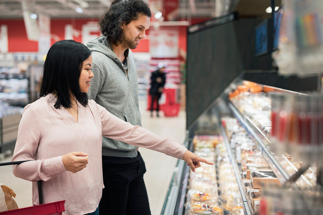Young couple shopping during inflation in supermarket\n