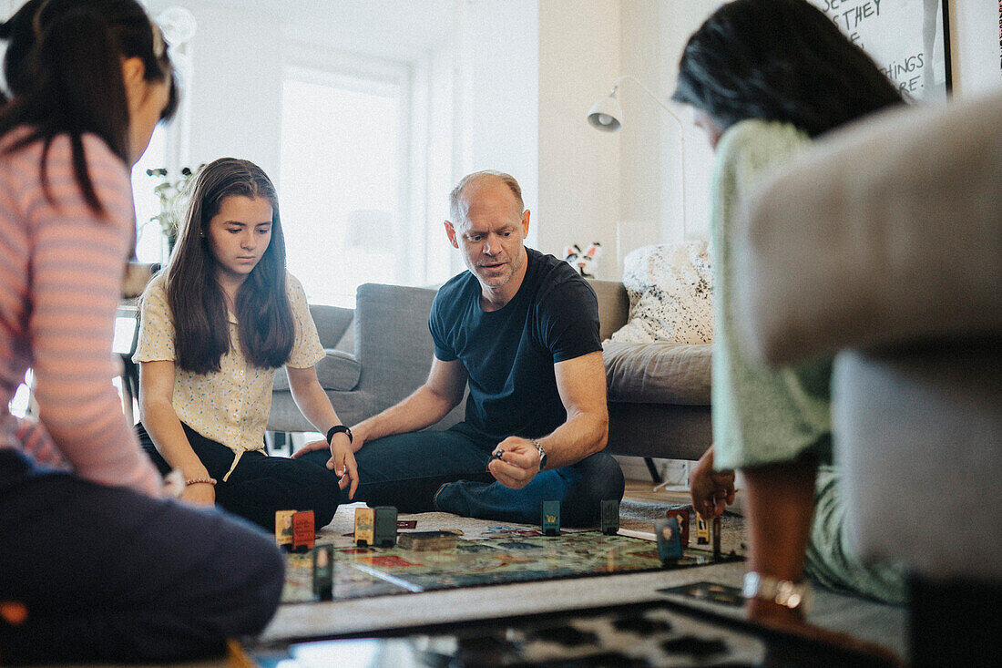 Family relaxing at home playing board games\n