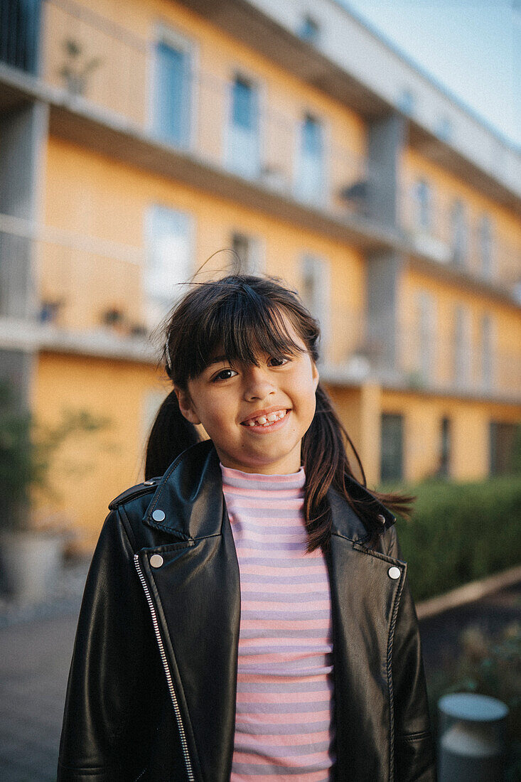 Porträt eines fröhlich lächelnden Mädchens in Lederjacke