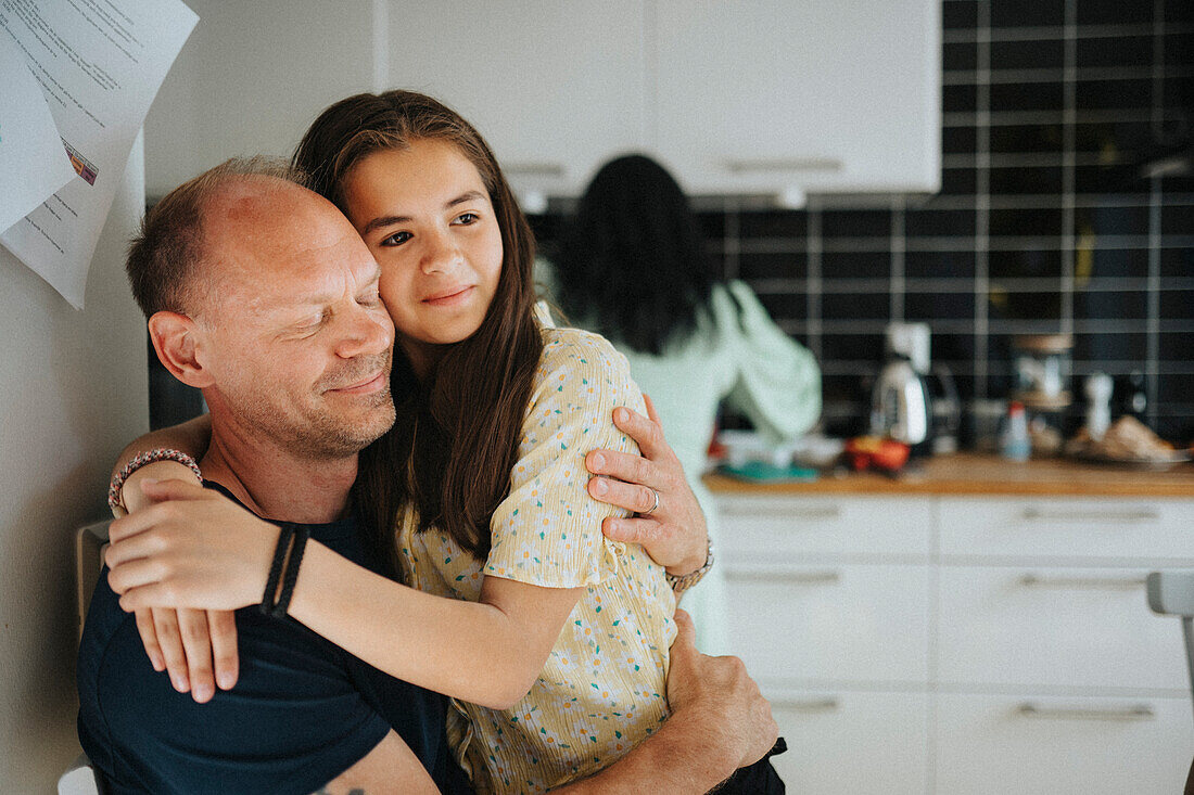 Loving father and daughter hugging at home\n