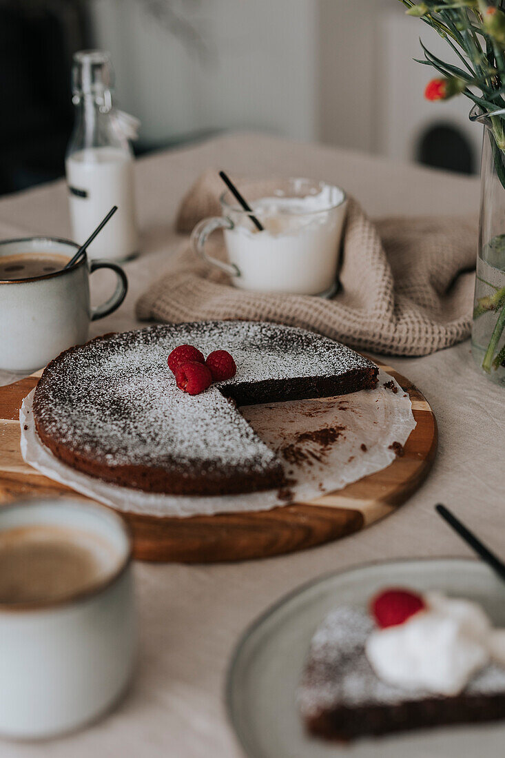 Freshly baked chocolate cake with raspberries on table\n