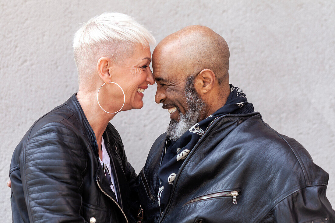 Affectionate mature biker couple in leather clothes\n
