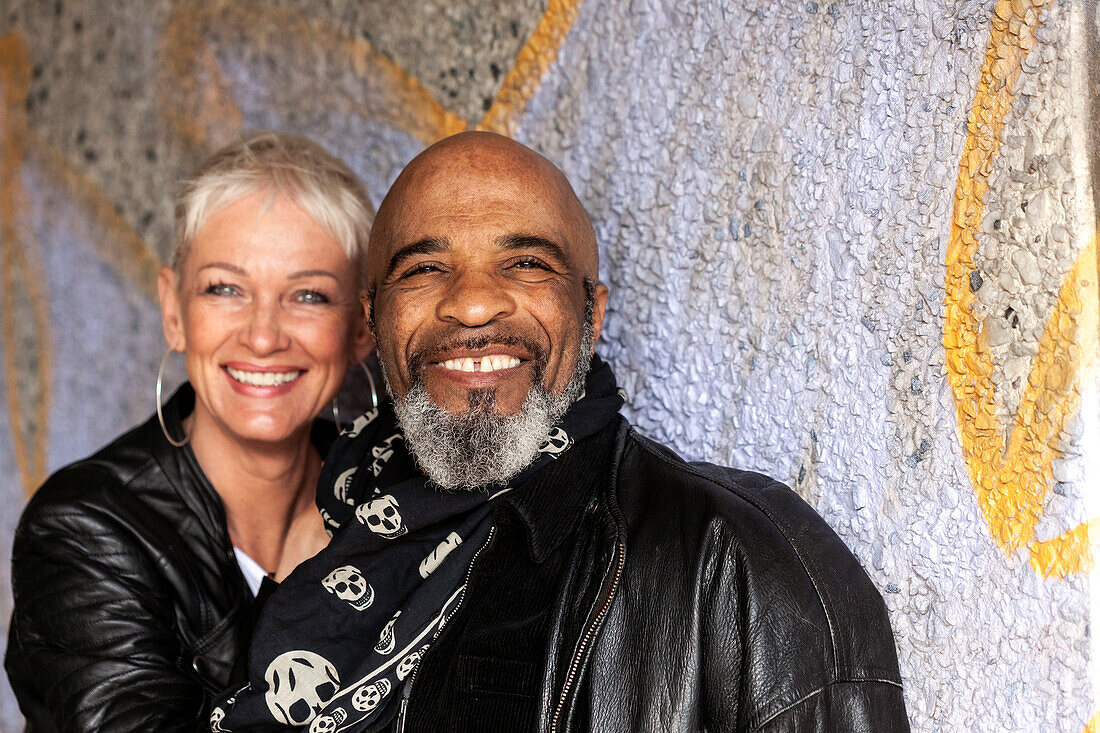 Portrait of happy mature biker couple in leather clothes\n