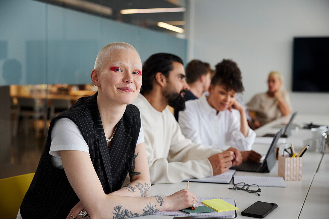 Woman sitting during business meeting and looking at camera\n