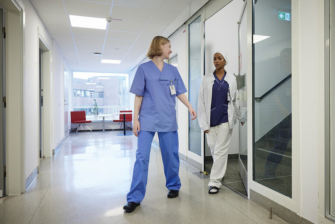Female doctors walking through hospital corridor\n