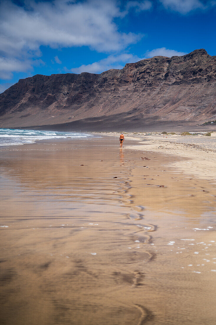 Strand von Famara (Playa de Famara), 6 km langer goldener Sandstrand im Naturpark des Chinijo-Archipels, zwischen dem Fischerdorf La Caleta de Famara und dem Fuß der beeindruckenden Klippen von Famara, Lanzarote, Kanarische Inseln, Spanien