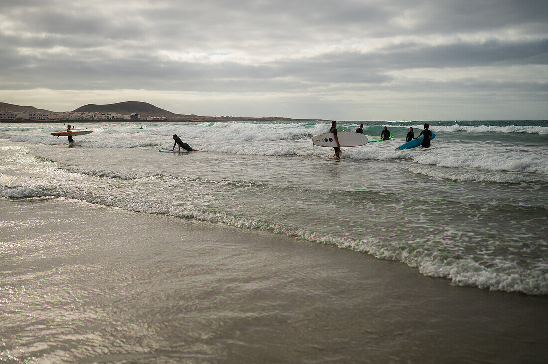 Strand von Famara (Playa de Famara), 6 km langer goldener Sandstrand im Naturpark des Chinijo-Archipels, zwischen dem Fischerdorf La Caleta de Famara und dem Fuß der beeindruckenden Klippen von Famara, Lanzarote, Kanarische Inseln, Spanien