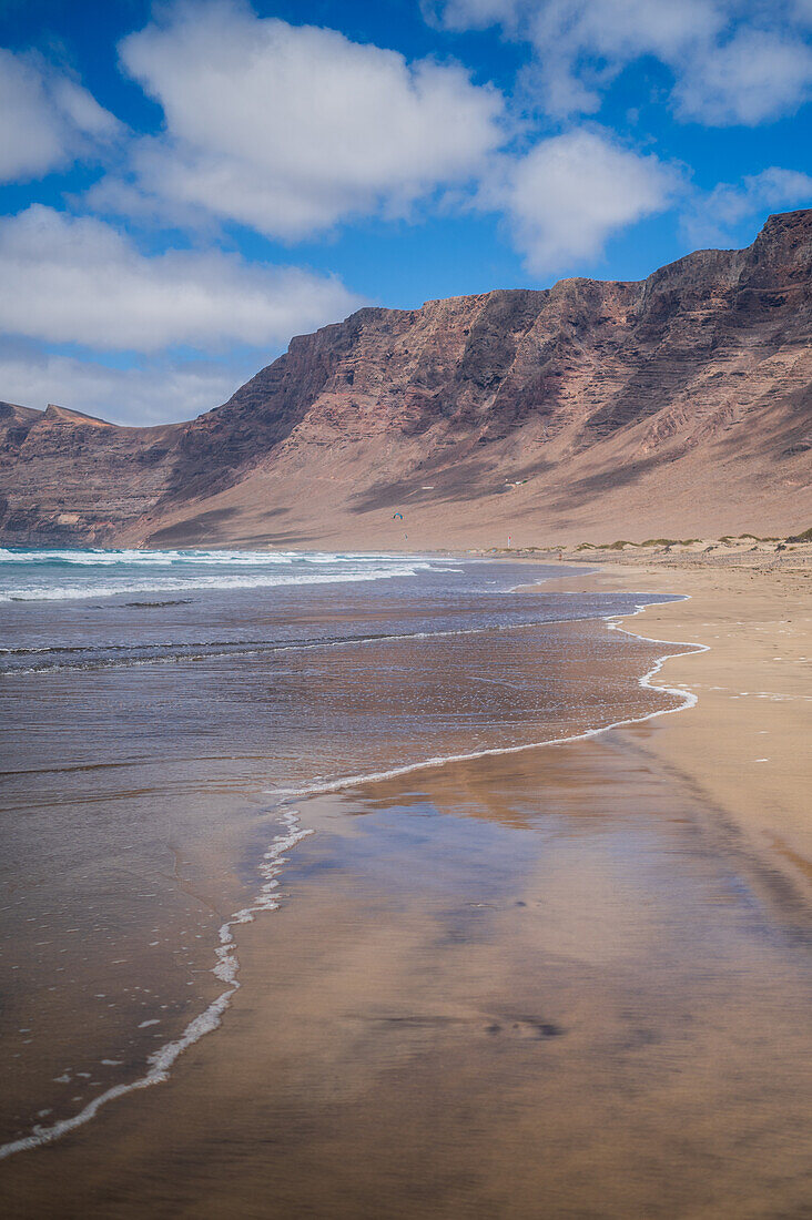 Strand von Famara (Playa de Famara), 6 km langer goldener Sandstrand im Naturpark des Chinijo-Archipels, zwischen dem Fischerdorf La Caleta de Famara und dem Fuß der beeindruckenden Klippen von Famara, Lanzarote, Kanarische Inseln, Spanien