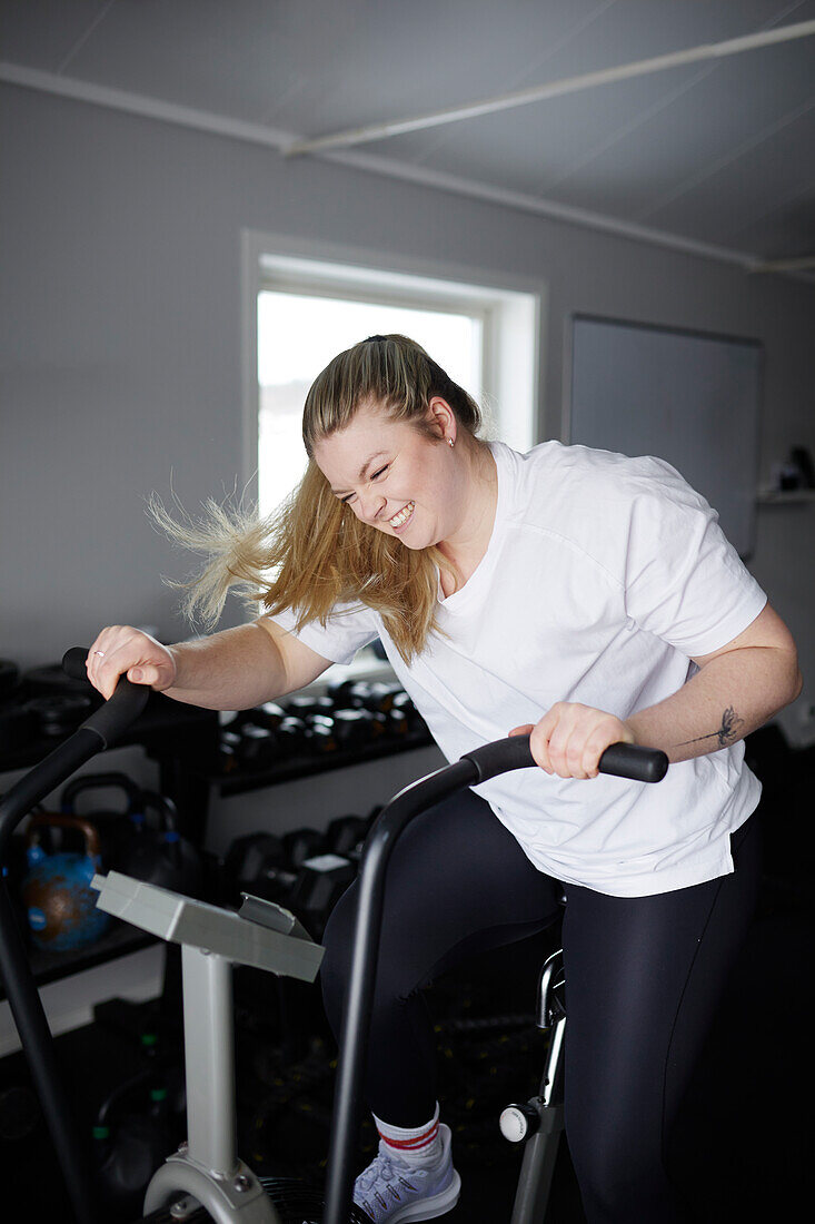 Blond woman exercising in gym\n